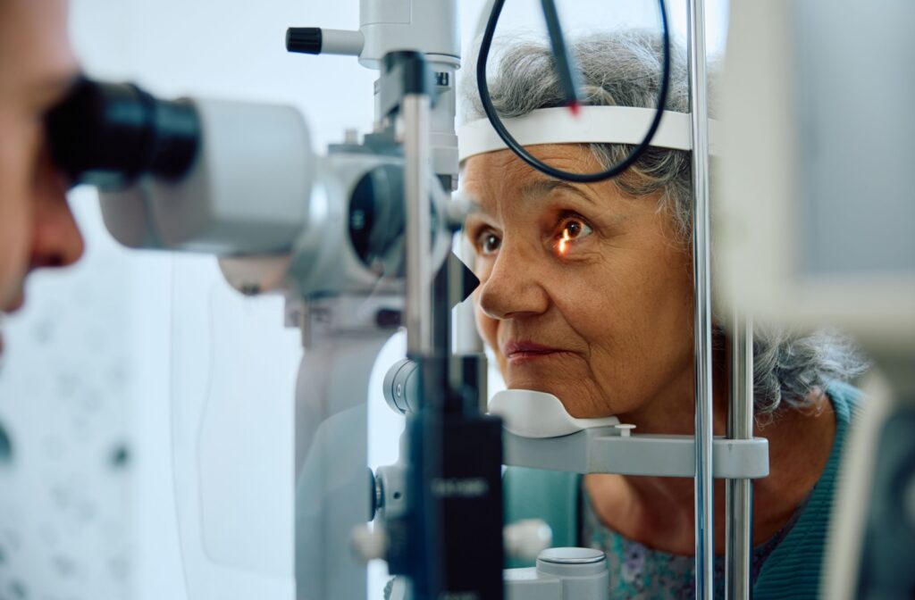 An older adult undergoing a slit lamp examination during their routine eye exam.
