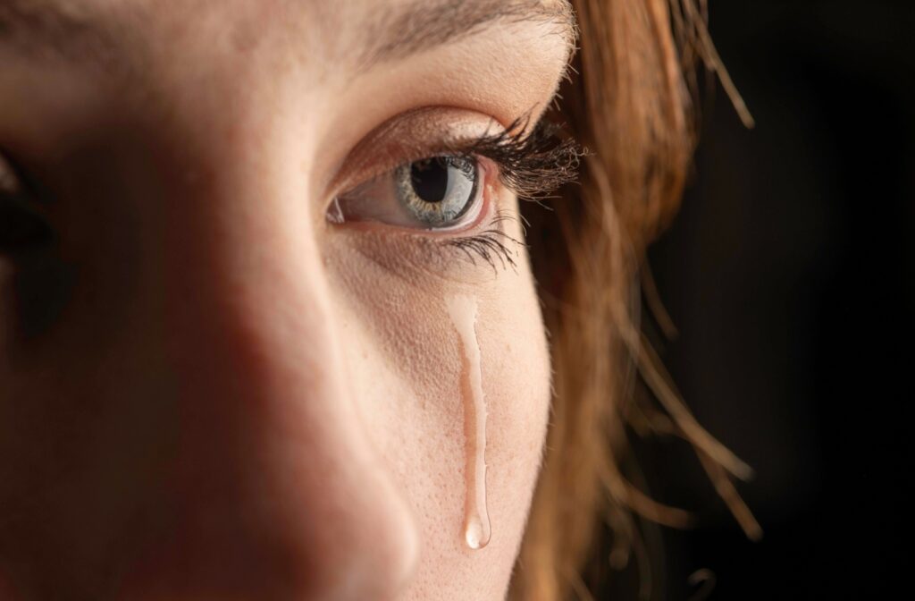 a close up of a person with tears streaming down their face.