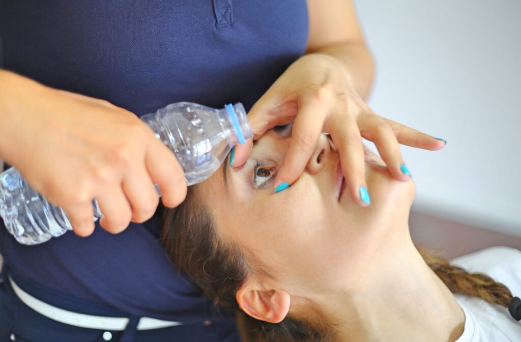 A person using water to gently rinse the dust out of their eye.