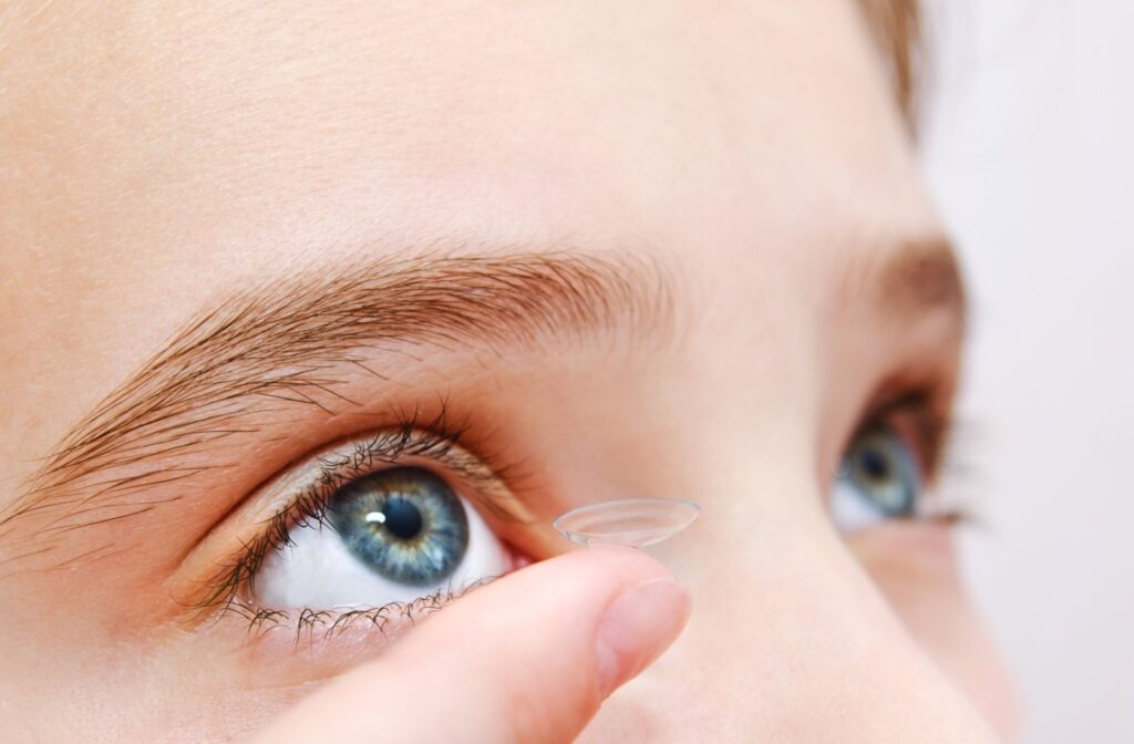 A close up of a kid putting in a specialty contact lens to help slow the progression of myopia.