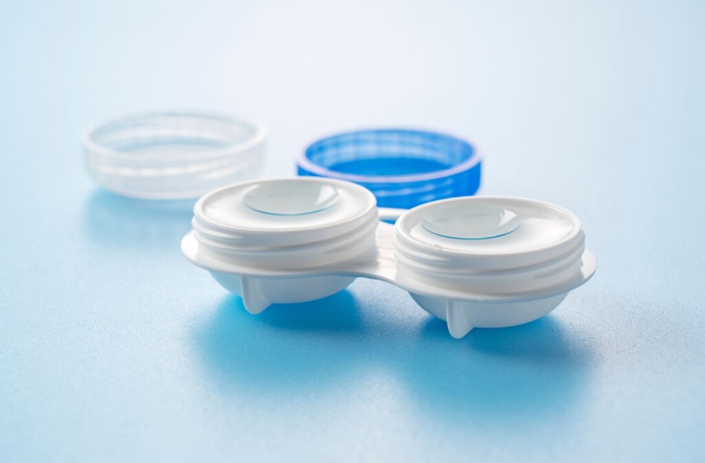 A pair of contact lenses sitting in contact lens solution in a contact lens case.